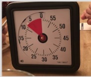 Analoge Küchenuhr mit rotem Zeiger und Minutenskala.