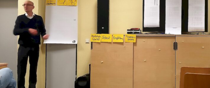 Feedback ist Trumpf Redner erläutert Bewertungsstrukturen neben Flipchart und beschrifteten Karten.