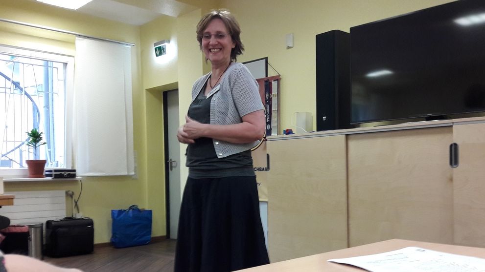 Lächelnde Toastmasterin des Abends steht vor dem Publikum im Clubraum der Kölner Sprechbar.