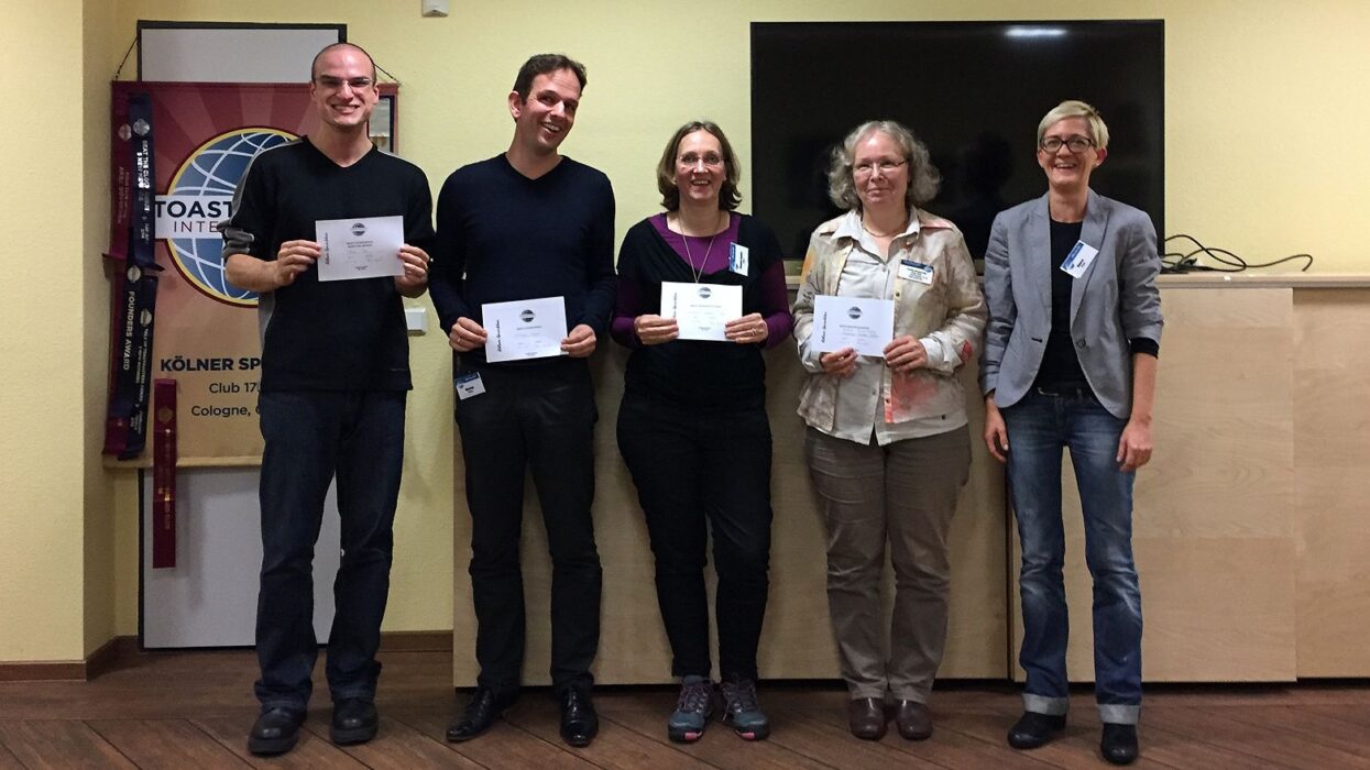 Gewinnerinnen und Gewinner des improvisierten Clubabends stehen lächelnd zusammen und halten ihre Urkunden in den Händen.