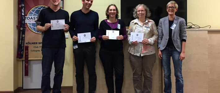 Gewinnerinnen und Gewinner des improvisierten Clubabends stehen lächelnd zusammen und halten ihre Urkunden in den Händen.
