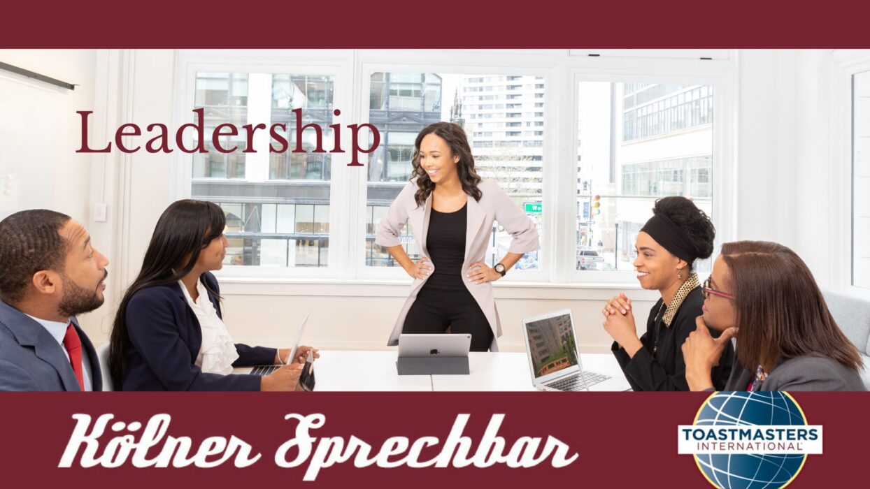 Dasselbe Konferenzraum-Foto, ergänzt um den Schriftzug „Kölner Sprechbar“ und das Toastmasters-International-Logo.