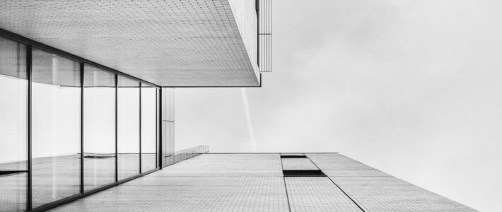 Schwarz-weiße Architekturaufnahme einer minimalistischen Gebäudefassade mit klaren geometrischen Linien.