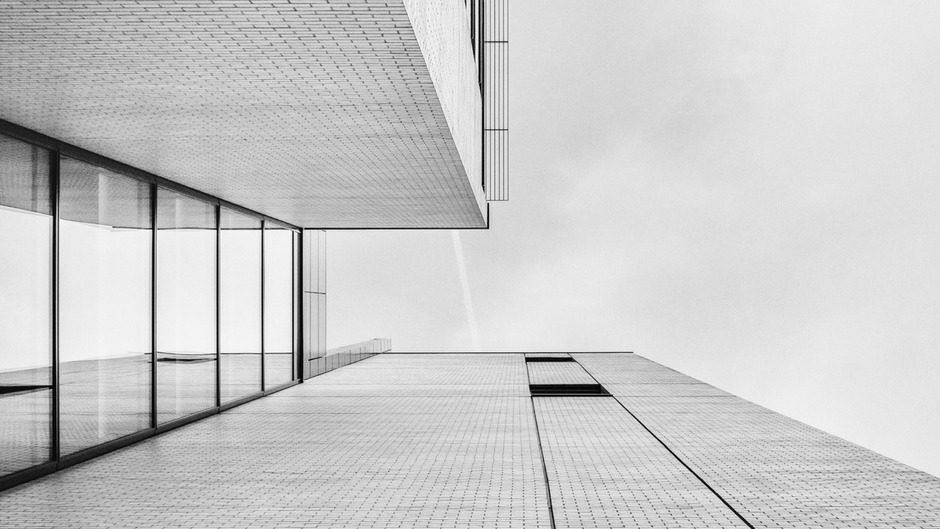 Schwarz-weiße Architekturaufnahme einer minimalistischen Gebäudefassade mit klaren geometrischen Linien.