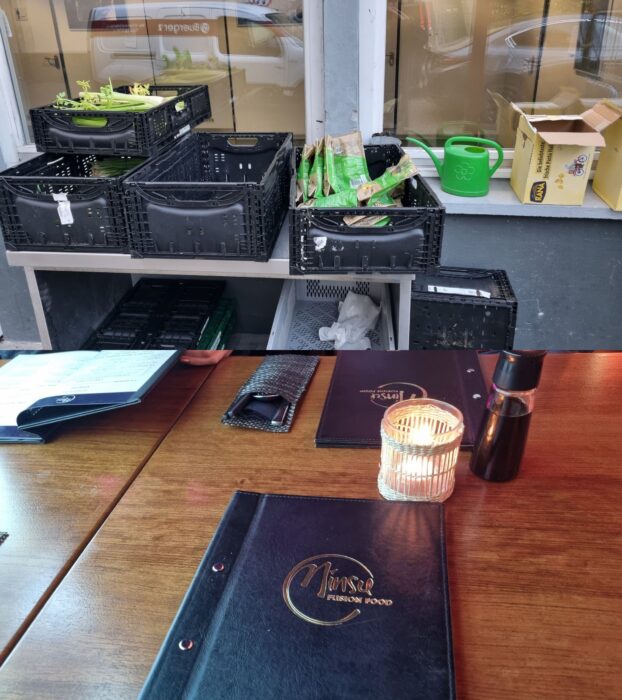 Kisten mit kostenlosen Lebensmitteln und ein gedeckter Restauranttisch nach dem Clubabend