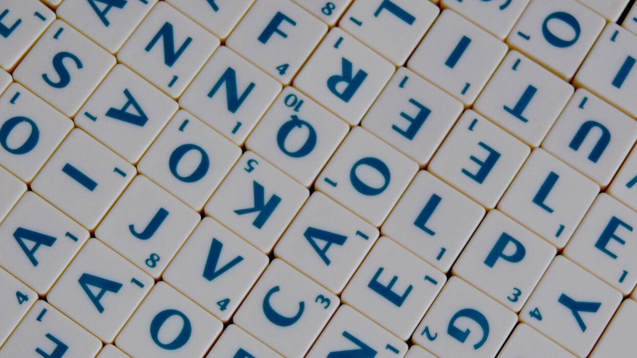Nahaufnahme von durcheinanderliegenden Scrabble-Buchstabensteinen.