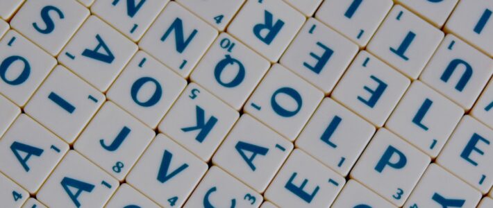 Nahaufnahme von durcheinanderliegenden Scrabble-Buchstabensteinen.