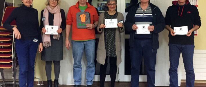 Sechs Mitglieder der Kölner Sprechbar stehen nach dem Clubabend mit Urkunden und Wanderpokal.