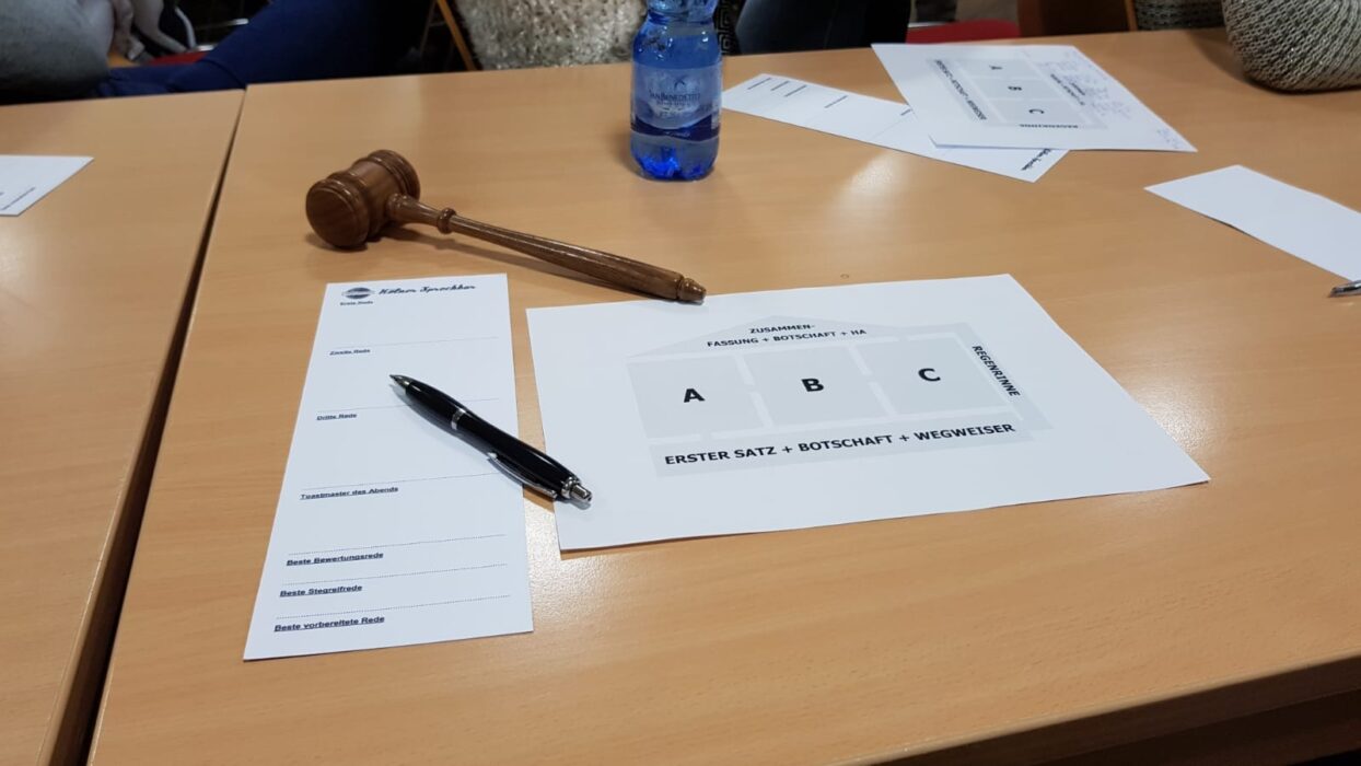 Hammer, Stift, Stimmzettel und Arbeitsblatt zur Rede-Struktur liegen auf einem Tisch.