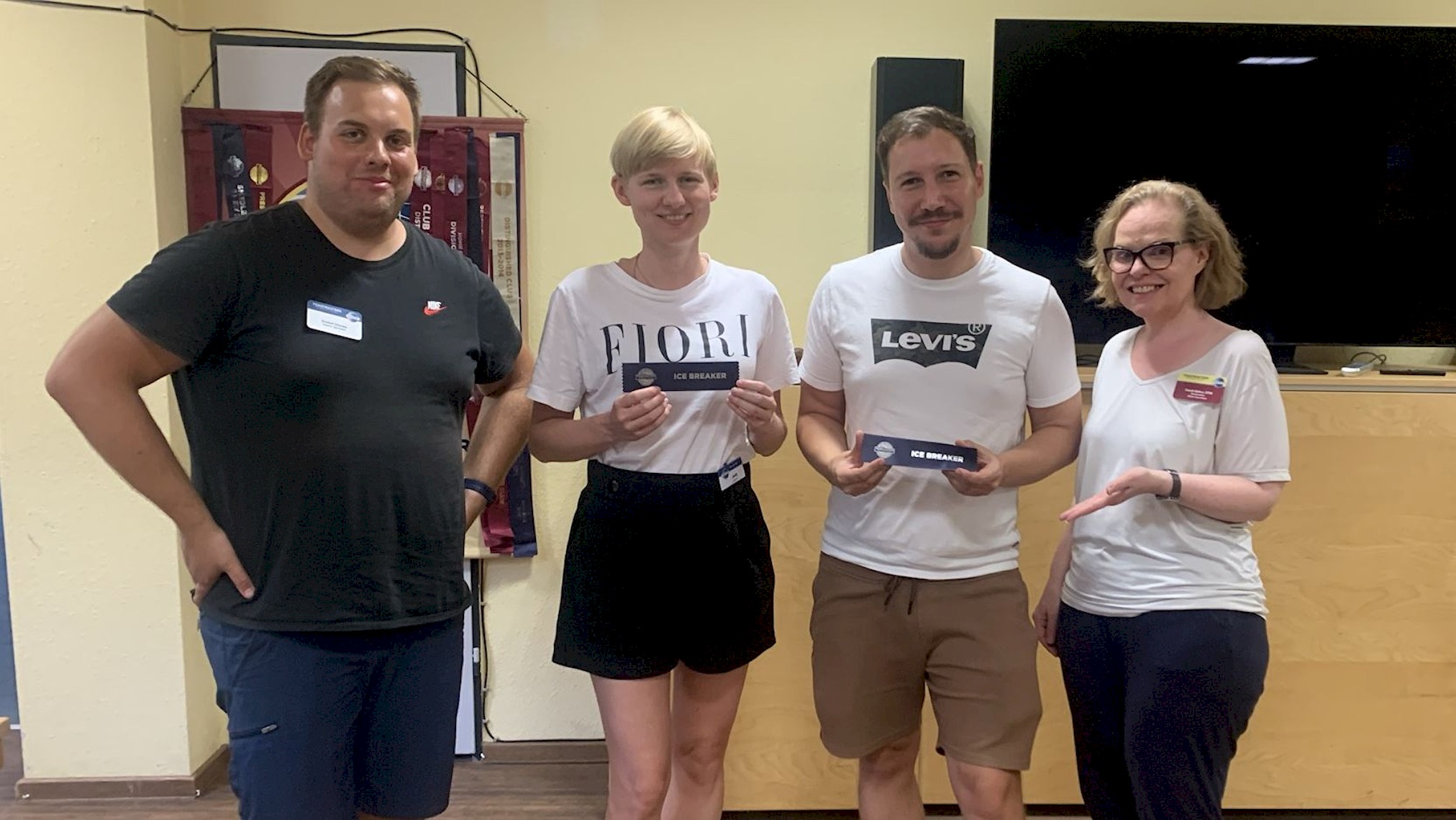 Vier Personen stehen bei einem Clubabend der Kölner Sprechbar; zwei halten Ice-Breaker-Auszeichnungen.