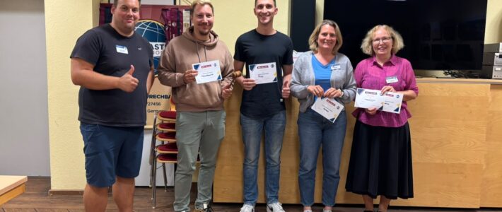 Fünf Teilnehmende stehen mit mehreren Urkunden und einem Rednerhammer im Clubraum der Kölner Sprechbar.